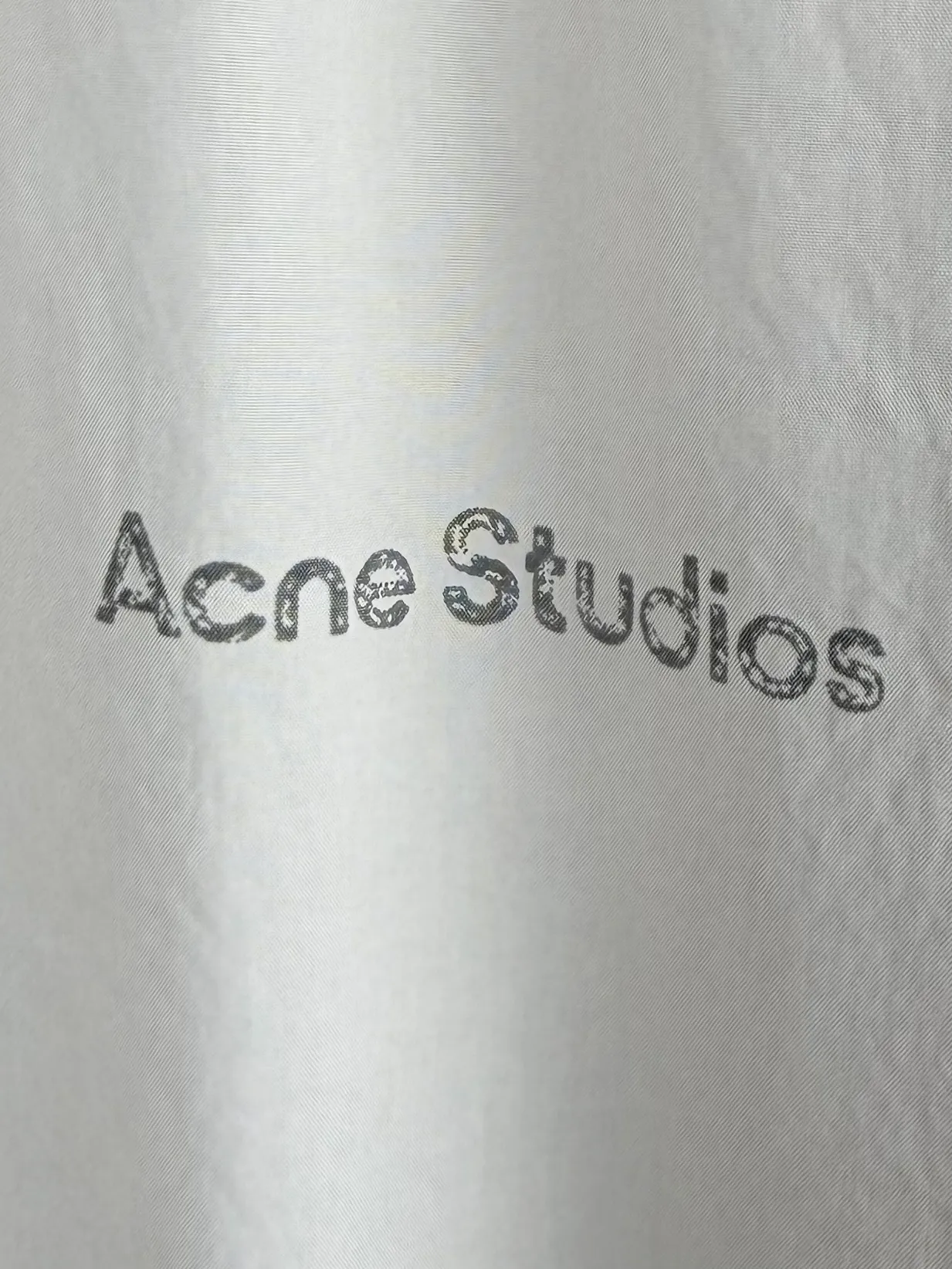 ACNE Studios Contrast Logo Distressed Zip Jacket Custom-made Dusty Royal Poplin Lightweight and crisp Dry and wind-resistant Sophisticated Royal Blue smudged body Washed mist softens the bright tones Interpreting the cool and relaxed luxury unique to Scandinavia Stand-up collar fully zippered coach jacket Elasticated hem cuffs Create a relaxed, drop-top short silhouette Fully lined interior with a smooth and neat upper body The Acne Studios print is discreetly engraved on the chest, retaining the brand gene in a restrained and subtle manner. The contrasting Acne Studios Retro emblem is laid out on the back of the garment. One simple and one complex form a clever visual contrast, which reflects the brand's heritage and traces back to the origin of the brand. It uses the Nordic minimalist high-end ready-to-wear language to describe the narrative of relaxed and restrained luxury and elegance. Process 1: Adopt glue printing process. The printing has been revised three times with the film screen. Use glue liquid paint to print the pattern on the fabric. Bake the fabric to fix the printed pattern. Process 2: Gradient distressed spray process. By spraying dyes of different colors on the surface of the fabric, the clothes can show rich color changes under different lights and increase the visual layering. Process 3: Heavy fermentation washing uses a special solution to remove stains and slight fading, and then snowflake washing. Use strong washing to fade the color to make the color more uniform. Process 4: The hem is made in one go using a three-needle waist-drawing machine. The elastic band and the fabric are sewn together in the same process using the special needle position and feeding mechanism of the machine. The three-needle design is more secure and can distribute pressure evenly to ensure that the elastic band and the fabric fit tightly. Accessories: Customized 1:1 Acne zipper Customized 1:1 Acne trademark Fit: Loose fit Size: 44 46 48 50
